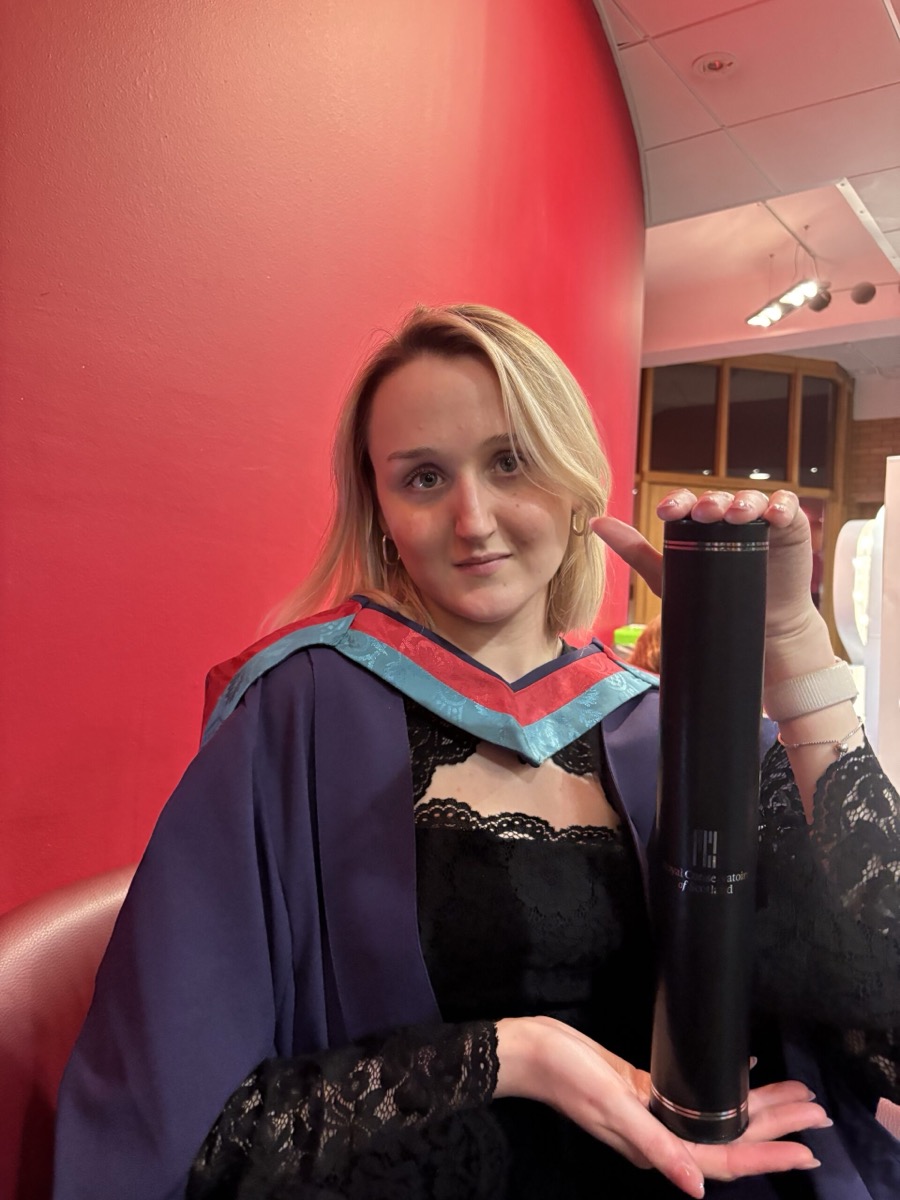 Molly Westbrook holding her graduation scroll.